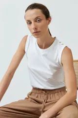 Musculosa roja de algodón con cuello redondo y botones decorativos en los hombros.