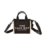 Bolso tote pequeño Marc Jacobs, color negro, confeccionado en tela jacquard con la inscripción "THE TOTE BAG MARC JACOBS" en blanco en el frente. Posee asas superiores y una correa extraíble y ajustable para llevar al hombro o cruzado.