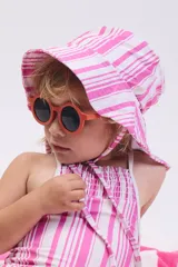 Gorro de playa para bebé con estampado de rayas irregulares rosas y blancas, con ala ancha y cordones para atar.