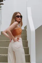 Pantalón jean wide leg color crudo con costuras rojas y ruedo desflecado.