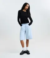 Cardigan blanco de punto liso con cuello redondo, mangas largas y cierre frontal con botones. El bajo es acanalado.