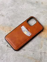 Funda de iPhone color marrón con bolsillo para tarjetas, diseño elegante y práctico.
