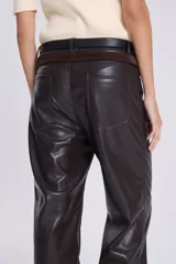 Pantalón recto de cuero sintético negro, estilo jeanero con tiro bajo, bolsillos delanteros y traseros, pretina con botón y pasacintos.