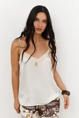 Musculosa de tirantes delgados con diseño bicolor: la parte superior es de color crema y la parte inferior es de color rosado pálido, ambas con acabado satinado.