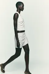 Falda pantalón negra de tiro alto con delantero cruzado y pliegues. Cierre trasero con cremallera oculta.