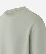 Remera verde claro de corte relajado, cuello redondo y manga larga. Confeccionada en tejido de media malla texturizada a rayas.