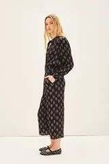 Pantalón capri negro con estampado floral, corte regular, bolsillos laterales y elástico en la parte trasera de la cintura.