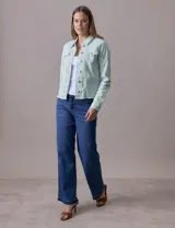 Campera de jean blanca, marca Baccini, con cuello solapa, bolsillos delanteros, abertura central con botones metálicos y terminación desflecada en el ruedo.