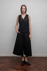 Blusa negra de microtul doble, con escote cruzado en V y drapeado suave. Diseño liviano y translúcido.