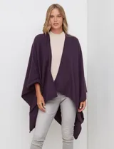 Ruana de tejido suave color morado oscuro, con cuello redondo y corte amplio tipo capa.