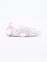 Pantuflas cerradas de tela suave color lila con estampado de corazones blancos y tirador rosa en el talón.