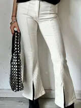 Pantalón de jean color crudo, de corte semioxford con aberturas en el ruedo.