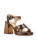 Sandalias de cuero color canela con plataforma y tacón ancho. Tiras cruzadas en el empeine y pulsera ajustable con hebilla en el tobillo.
