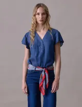 Blusa celeste de tencel con escote en V y botones. Tiene mangas cortas amplias con volados.