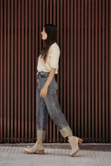 Sweater color dorado de tejido de punto suave con hilos metalizados, corte recto y mangas cortas con puño ajustado.