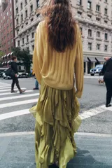 Falda midi color verde oliva, de tiro medio con cintura elástica y volantes asimétricos.