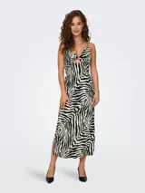 Vestido midi con estampado de cebra en blanco y negro, con breteles finos, escote en V con abertura en el centro y tajo lateral.