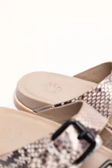 Sandalias marrones de cuero vacuno con doble tira y hebillas metálicas ajustables.