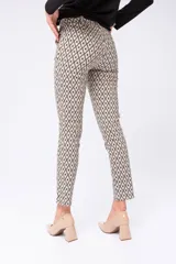 Pantalón de vestir beige con estampado geométrico de rombos negros. Corte ajustado con bolsillos delanteros funcionales y falsos bolsillos traseros.