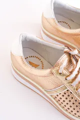 Zapatillas de cuero color dorado con diseño perforado, cordones blancos y suela de goma.