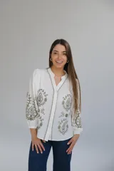 Camisa blanca de manga larga con elástico en puños, cuello mao con botones en la parte delantera y bordados florales en verde.