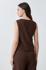 Chaleco sastrero color chocolate, de lino, con cuello en V y cierre frontal con botones.