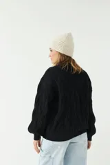 Sweater negro de punto grueso con diseño de trenzas.
