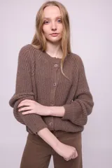 Cardigan marrón de mohair con cuello redondo, mangas largas abullonadas y cierre frontal con botones al tono.