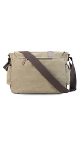 Morral de tela canvas color gris con detalles en cuero marrón. Tiene tapa con hebillas, doble bolsillo frontal, trasero y laterales. Interior espacioso con compartimento para notebook de 15". Correa de galón regulable.