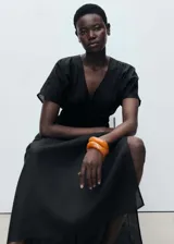 Vestido largo negro con escote en V, mangas cortas y cintura elastizada.