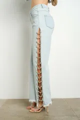 Pantalón de jean celeste con lavado claro, tiro alto, corte recto y apliques de gemas en aberturas laterales.