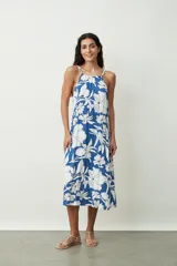 Vestido midi con estampado floral blanco sobre fondo azul, con breteles finos y corte recto.