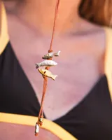 Gargantilla con hilo de algodón color camel y tres dijes de peces realizados en bronce, alpaca y plata 925.