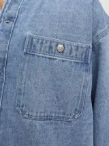 Sobrecamisa de jean celeste con manga larga, cuello clásico, cierre con botones y bolsillo frontal.