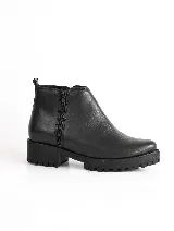 Bota corta negra de cuero vacuno, con cierre lateral, forro y plantilla de cuero y suela de caucho antideslizante.