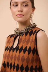 Vestido corto sin mangas con estampado de rombos en amarillo, azul y rojo. Tiene escote con abertura en forma de gota y ruedo con terminación en picos.