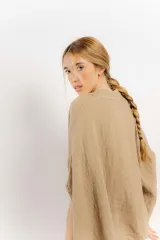 Camisa celeste de lino con corte amplio, cuello mao y mangas cortas. Presenta cierre frontal con botones y ribete negro en cuello y tapeta.