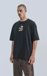 Remera negra de manga corta con cuello redondo y calce oversize. Estampado frontal de Mickey Mouse andando en skate.