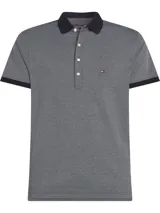Chomba Tommy Hilfiger gris con textura de micropuntos, cuello y puños negros, cartera de cuatro botones y logo bordado en el pecho.