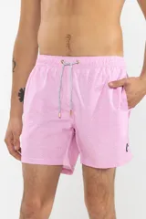 Short de baño rosa con estampado de lunares blancos, cintura elástica con cordón ajustable, bolsillos laterales y trasero con cierre, logo de la marca bordado en la pierna y suspensor de malla fina.
