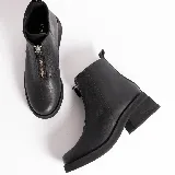 Botas cortas de cuero color marrón con cierre frontal con cremallera, suela de goma y taco bajo.