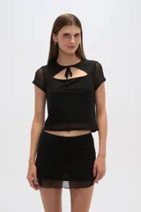 Top negro de poliéster con mangas cortas, cuello redondo, corte ajustado y abertura en el pecho.