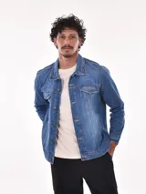 Campera de jean azul con cuello clásico, cierre frontal con botones metálicos, bolsillos con solapa abotonada en el pecho y bolsillos laterales.