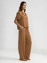 Camisa negra de manga corta en crepé de viscosa suave, con cuello camisero y detalle floral en la botonadura central.