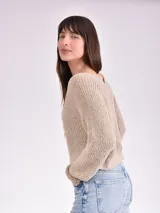 Sweater color crema de tejido de punto con escote en V.