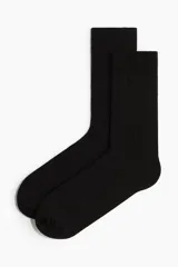 Pack de tres pares de medias de vestir negras, de caña media, confeccionadas en tejido de punto de algodón con textura acanalada y puño elástico.