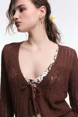Cardigan marrón de tejido de punto calado, con escote en V y cierre frontal con lazos.