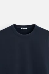 Sudadera negra de corte holgado, cuello redondo y mangas largas con puños acanalados.