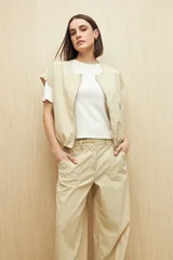 Pantalón color beige de corte ancho y tiro alto, con bolsillos delanteros amplios.