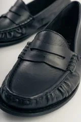 Mocasines de cuero negro con detalle de antifaz.